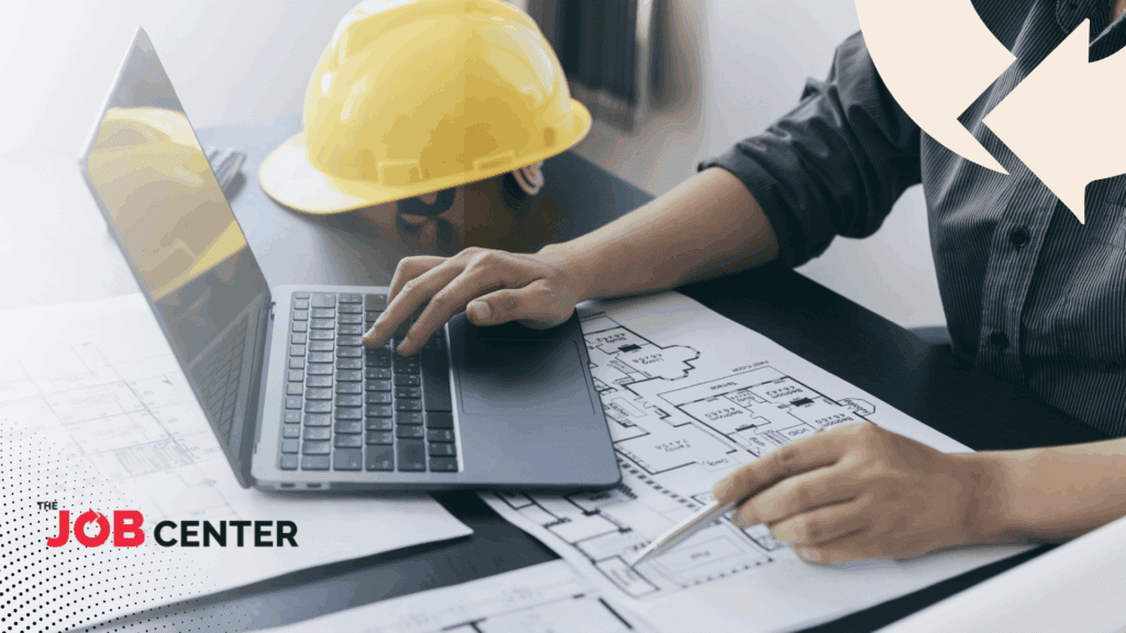 Manufacturing leader works at desk with laptop and blueprints next to a hard hat.