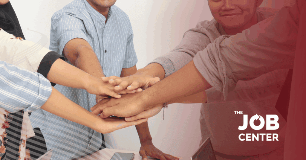 Temporary employees gather in a circle with hands meeting in the middle